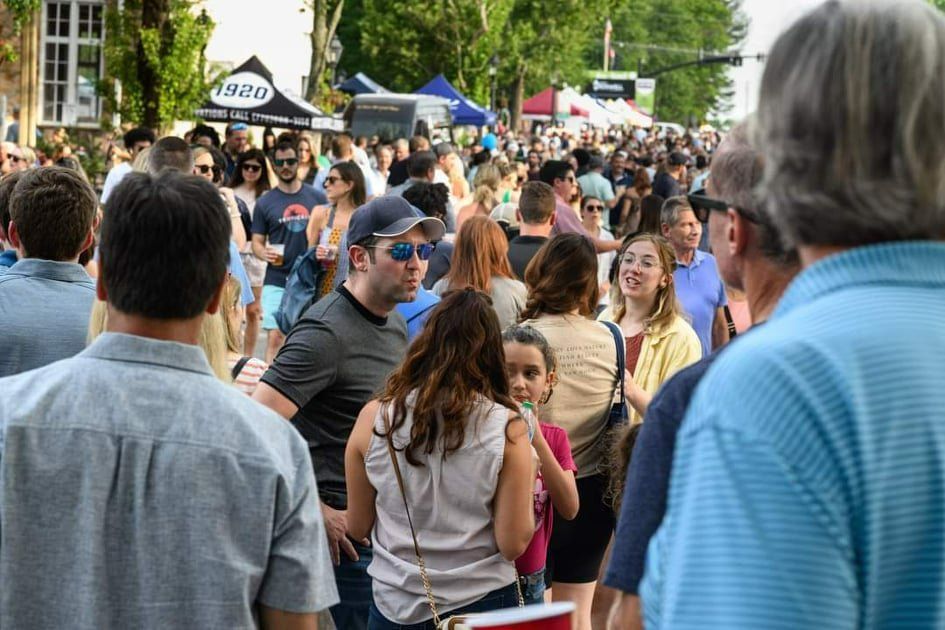 A crowd of people are standing in a line at a festival.