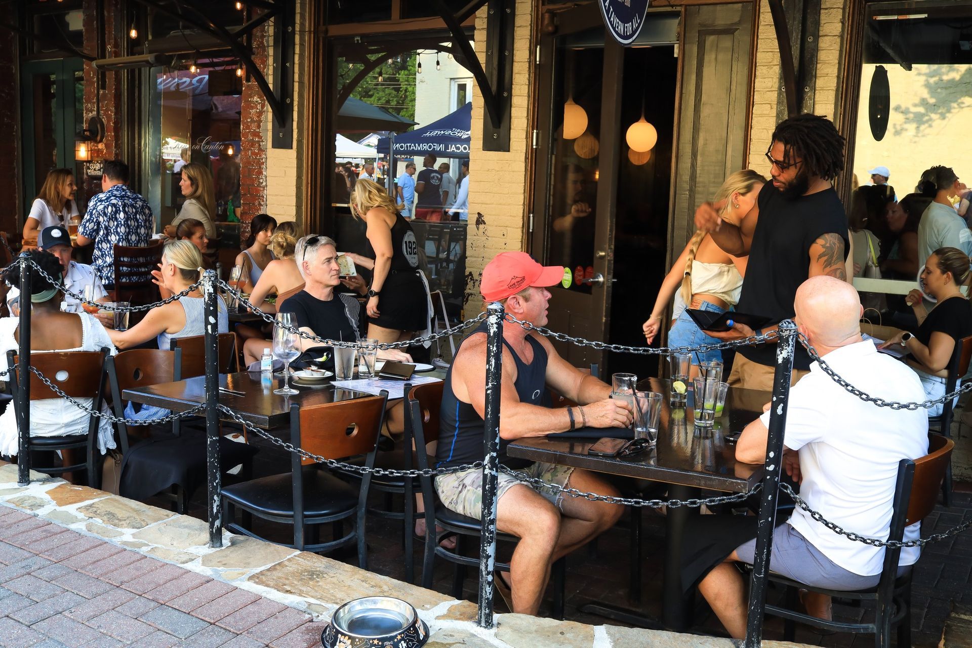 A group of people are sitting at tables outside of 1920 Tavern in Roswell GA.