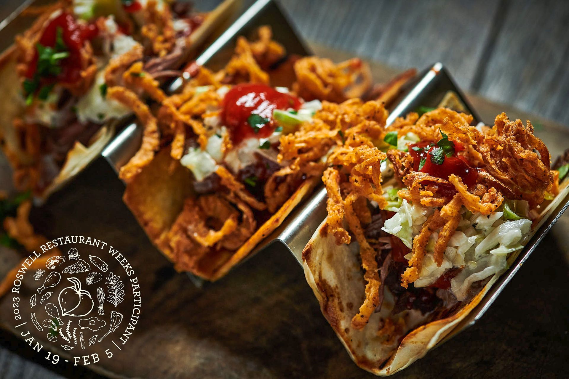 A close up of three tacos on a wooden table
