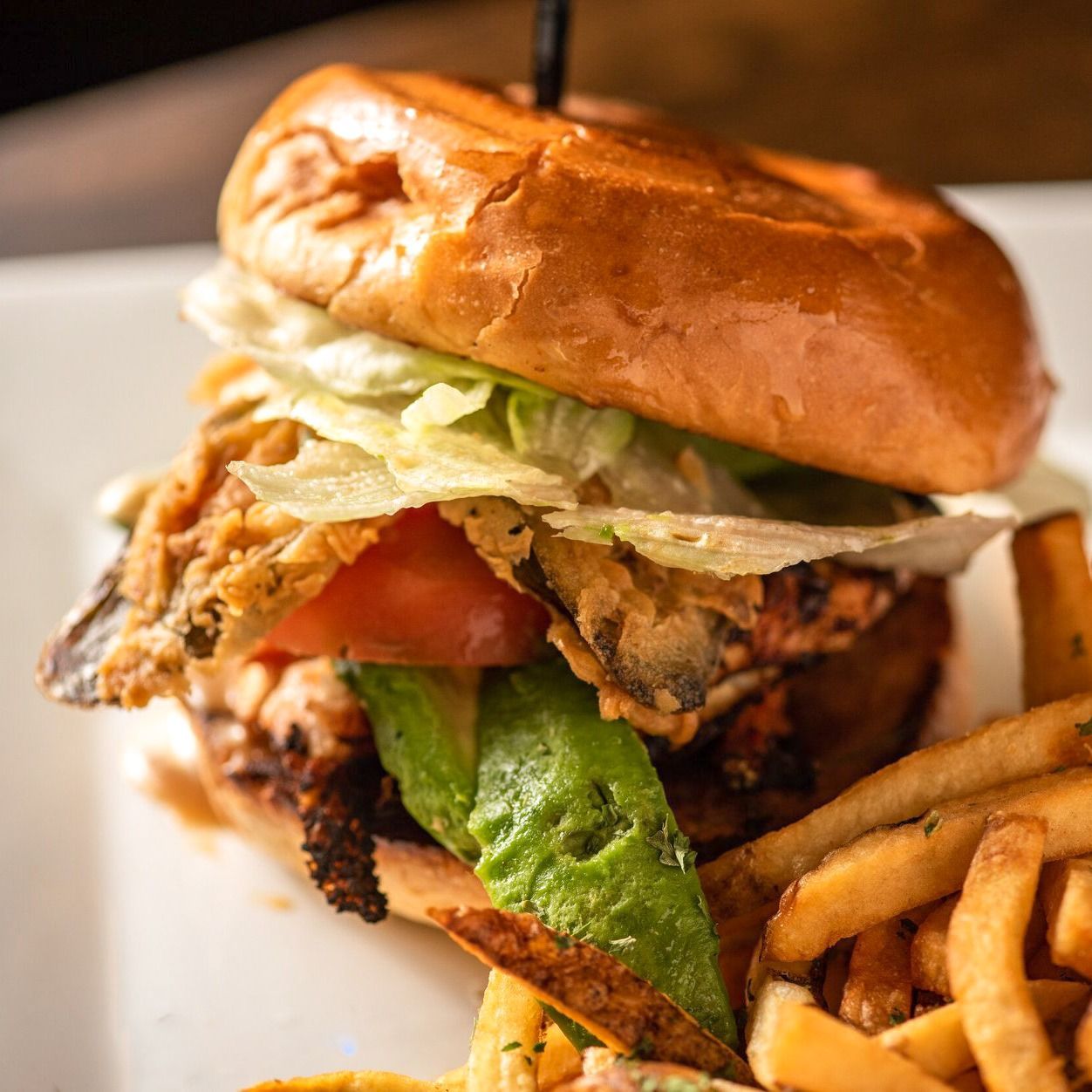 A close up of a sandwich and french fries on a plate.