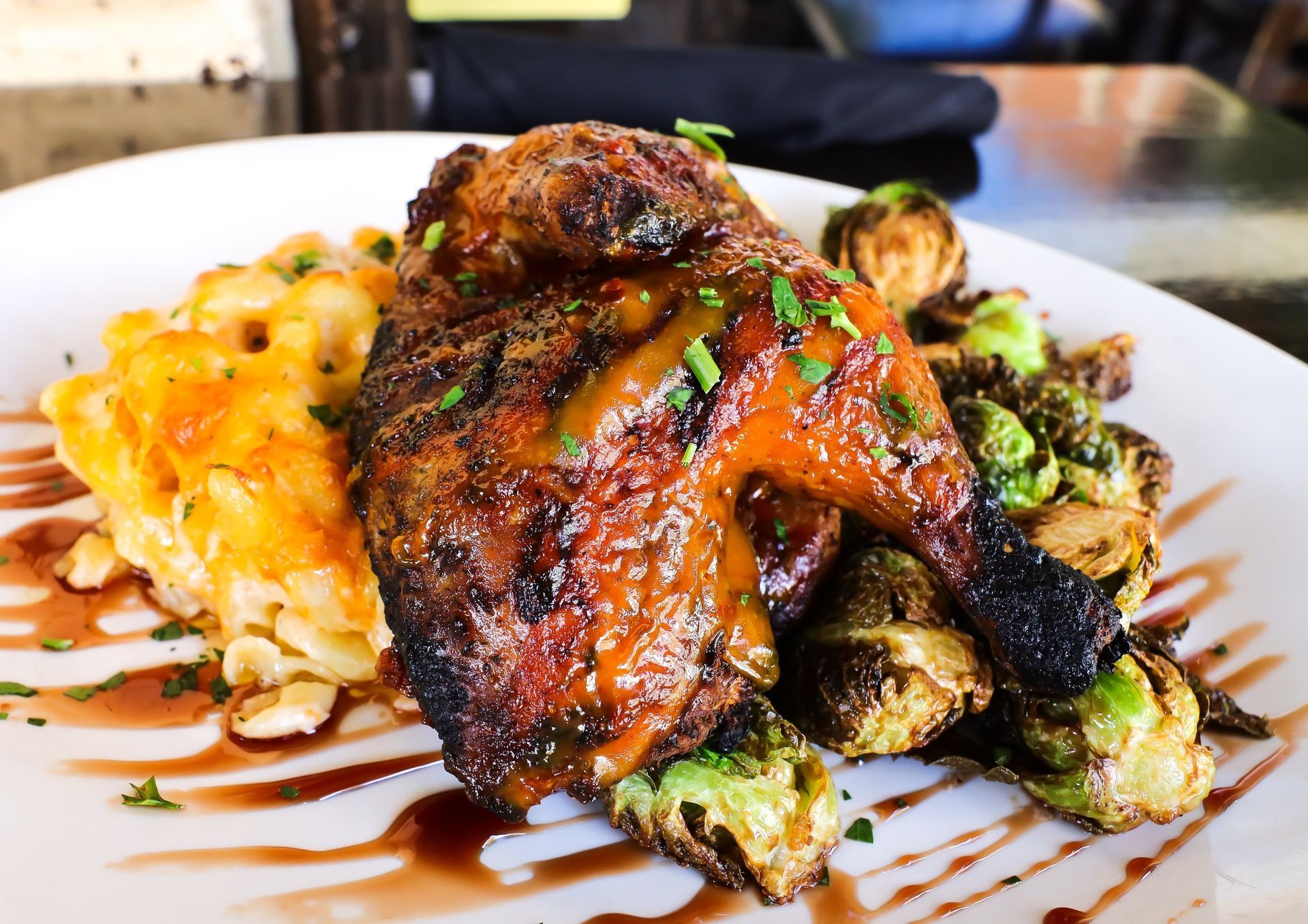 A white plate topped with meat and vegetables on a table.