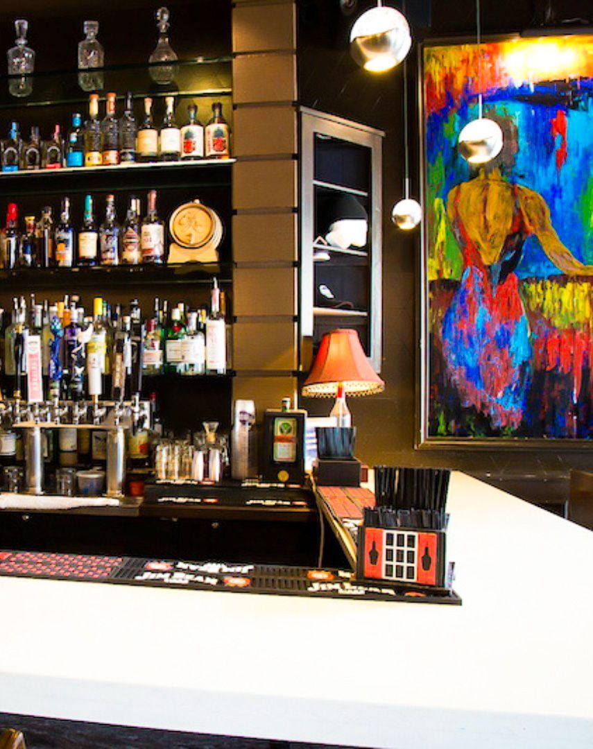 A bar with a painting on the wall behind it