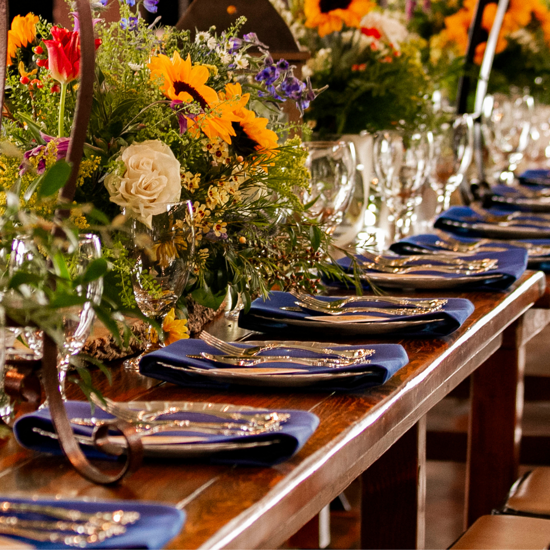 A long table with plates and silverware and flowers on it
