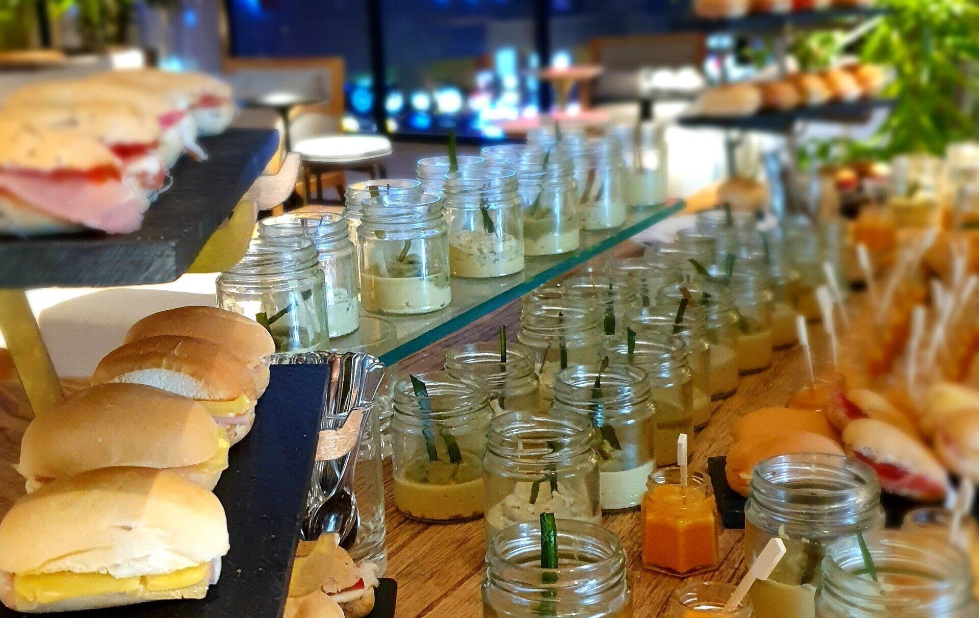 Una mesa de desayuno buffet llena de mucha comida y tarros de salsa.