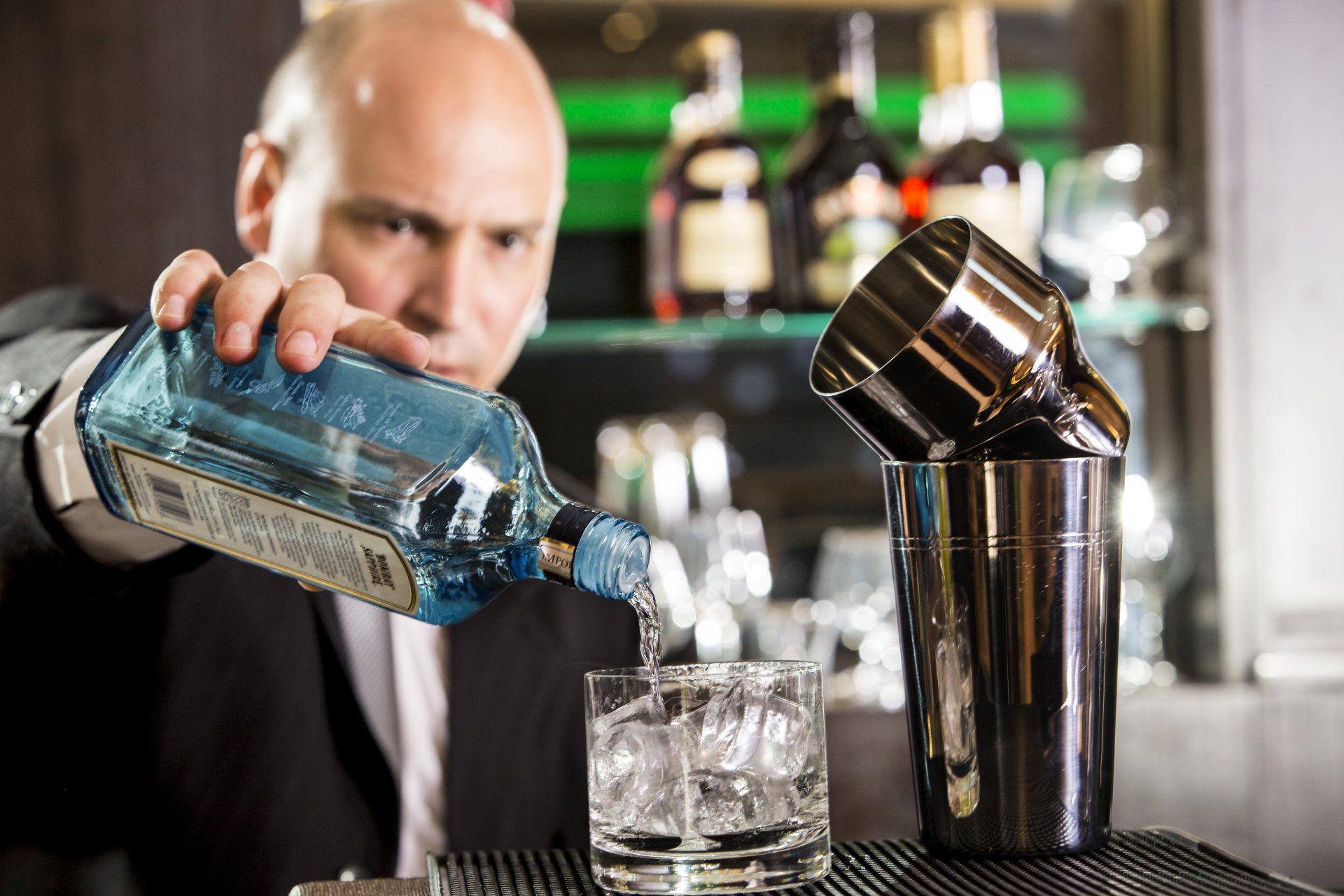 Un camarero está sirviendo una bebida en un vaso con hielo.