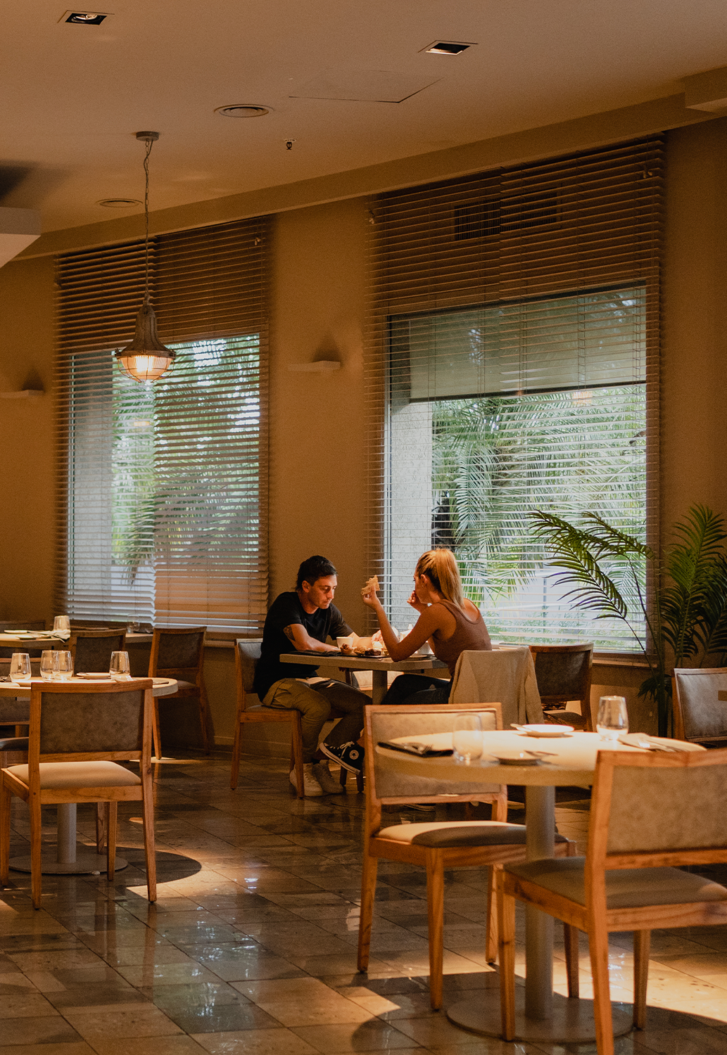 Un hombre y una mujer están sentados a las mesas de un restaurante.
