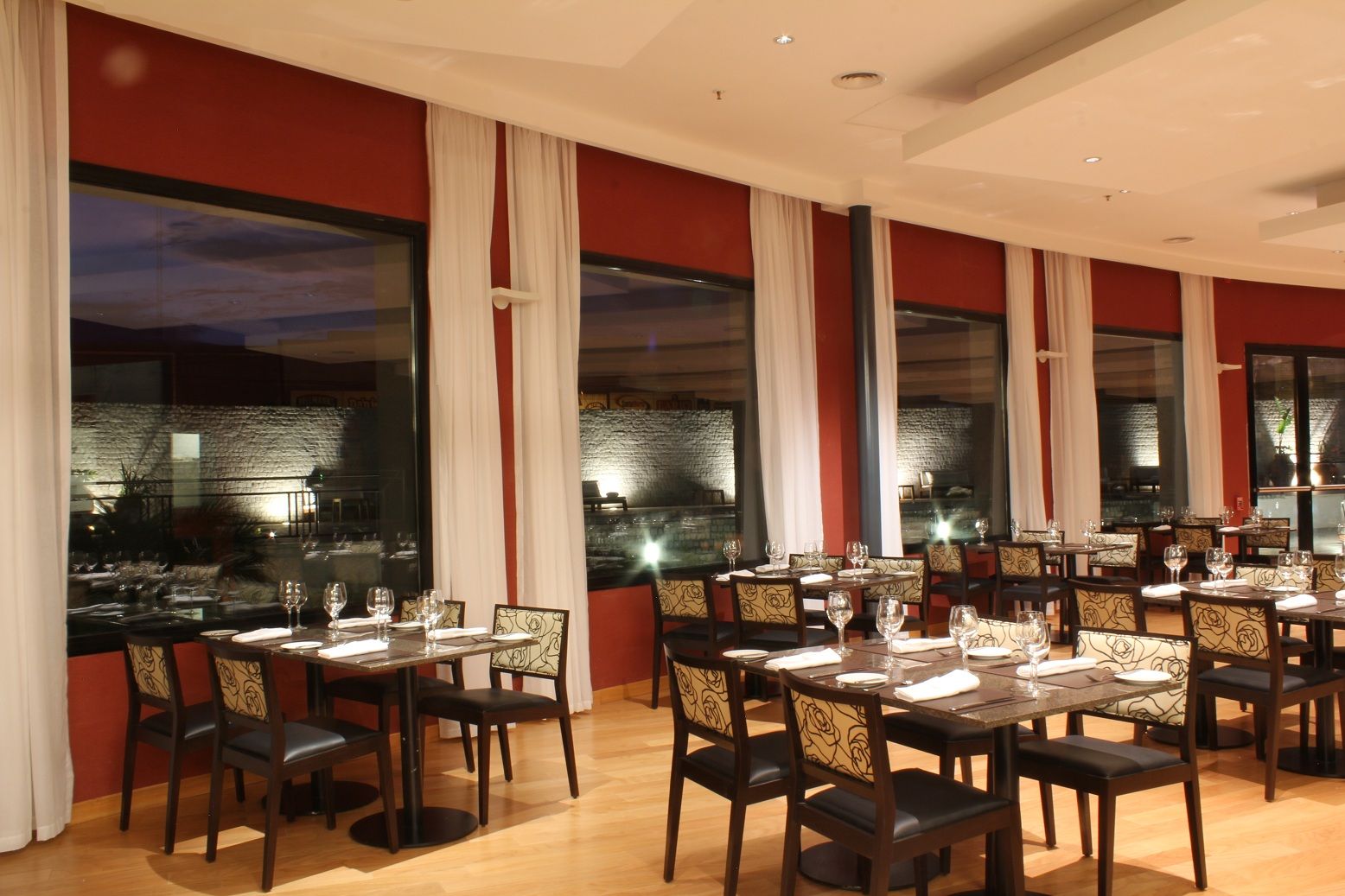 Un restaurante con mesas y sillas y muchas ventanas