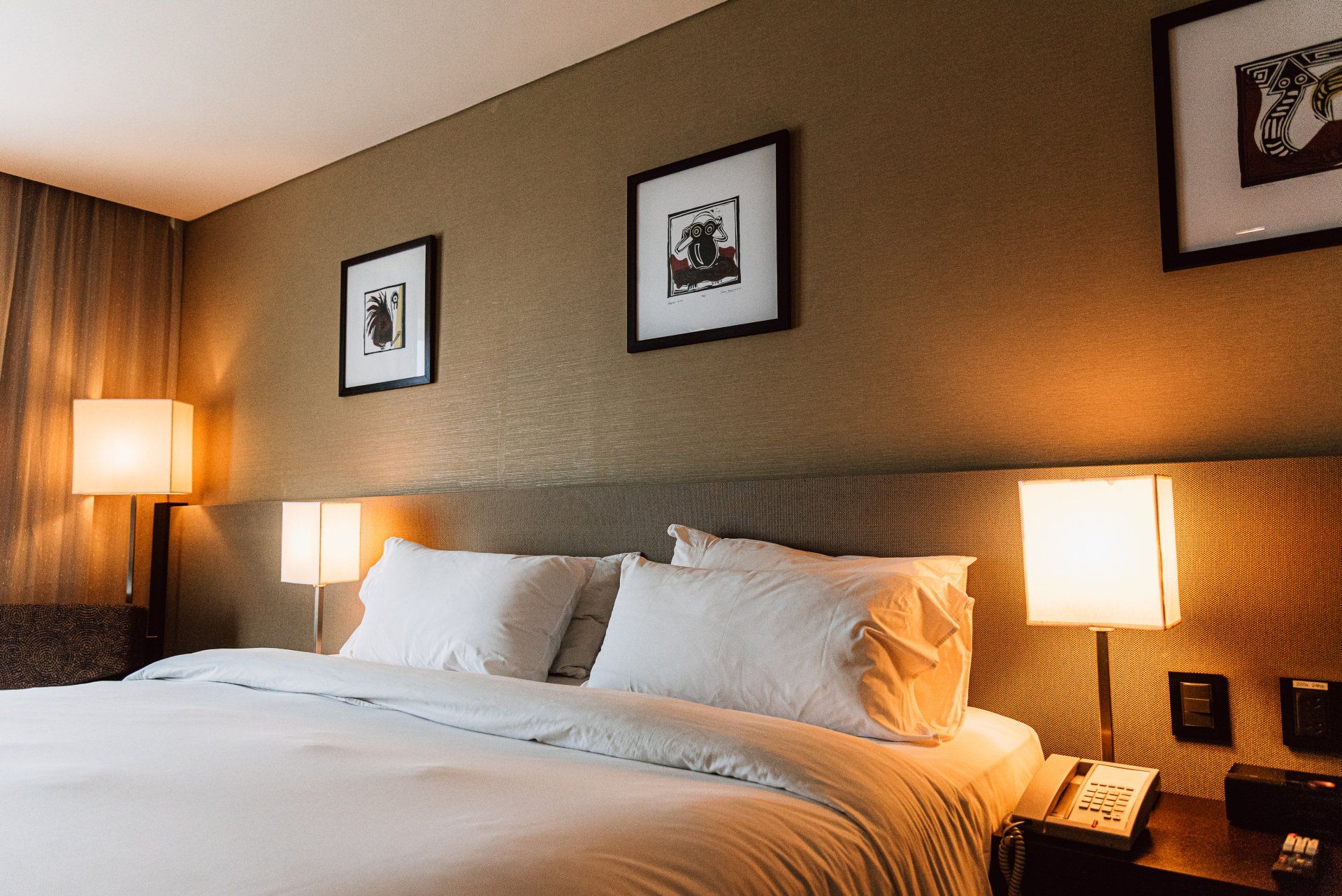 Una habitación de hotel con una cama king size, dos lámparas y una silla.