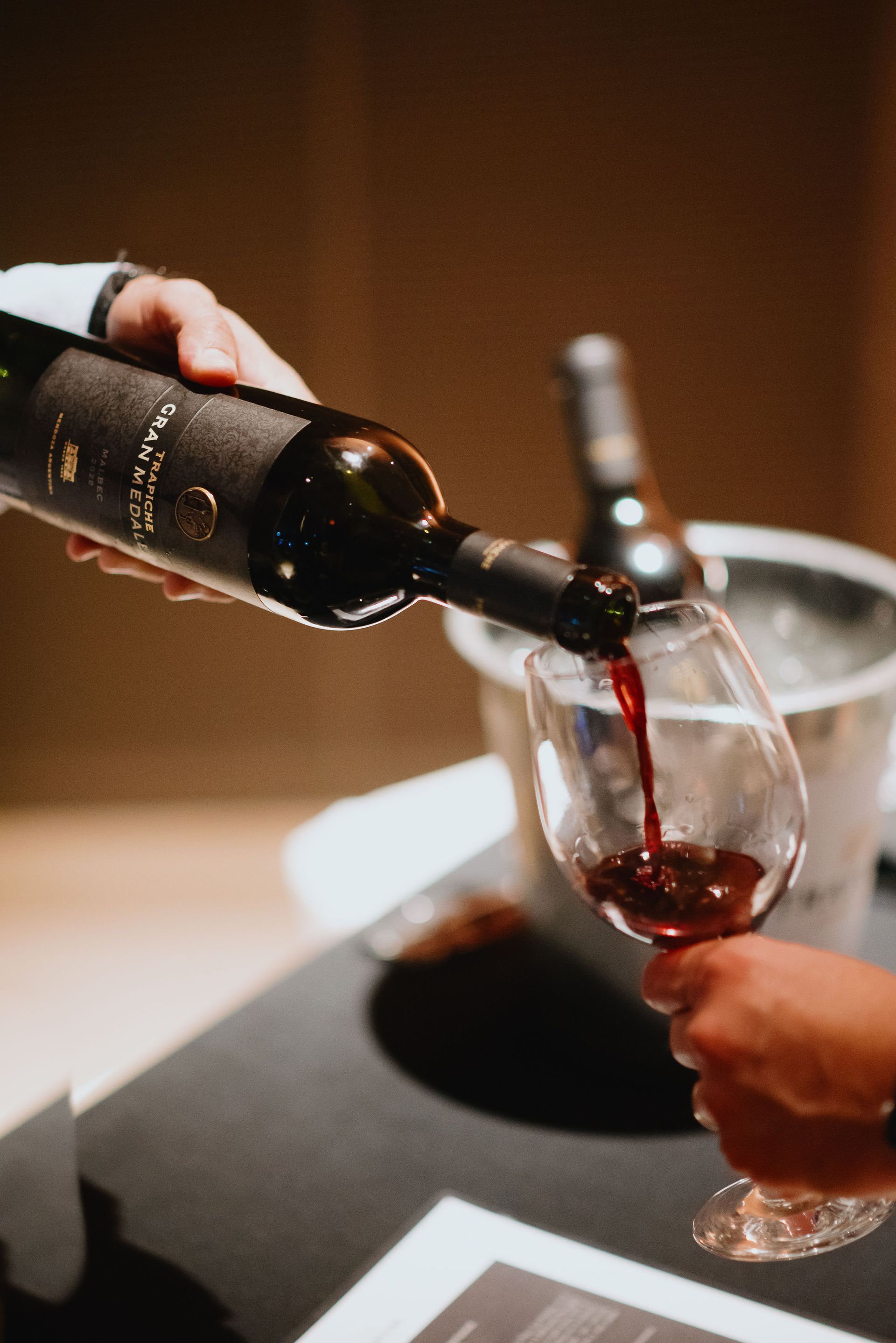 Se vierte una botella de vino en un vaso sobre una mesa.