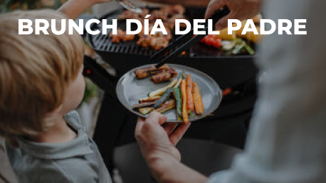Una mesa cubierta con platos de comida y un vaso de jugo de naranja.