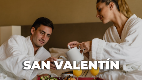 Una mesa cubierta con platos de comida y un vaso de jugo de naranja.