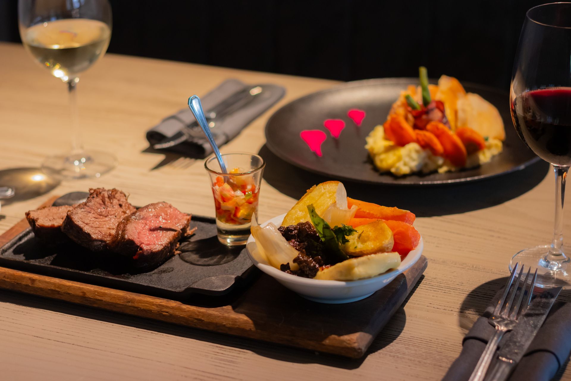 Dos mujeres sostienen copas de vino y hablan entre sí en una fiesta.