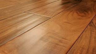 Close-up of glossy, brown hardwood floor planks, with wood grain visible.