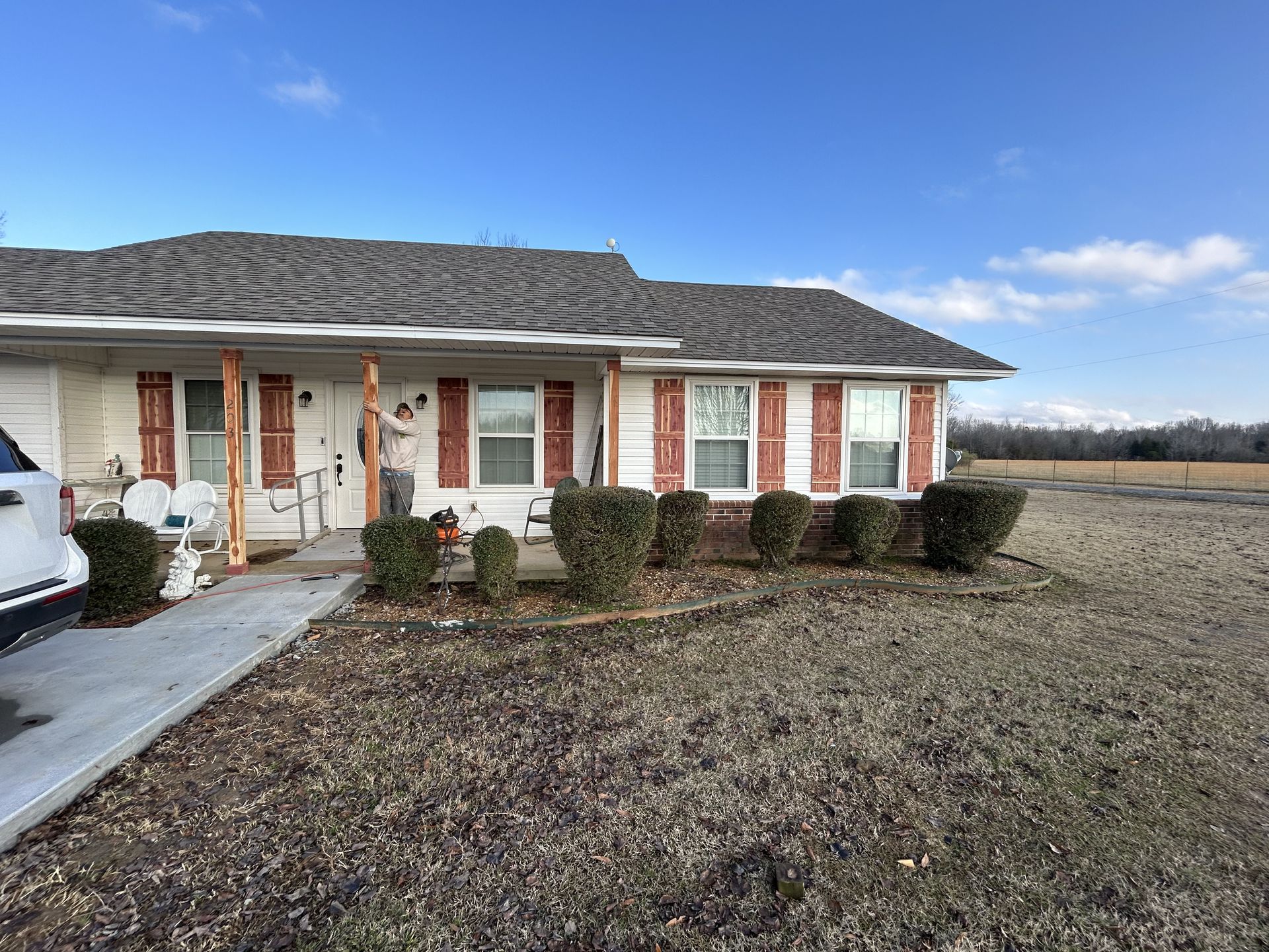 A white house with a car parked in front of it.