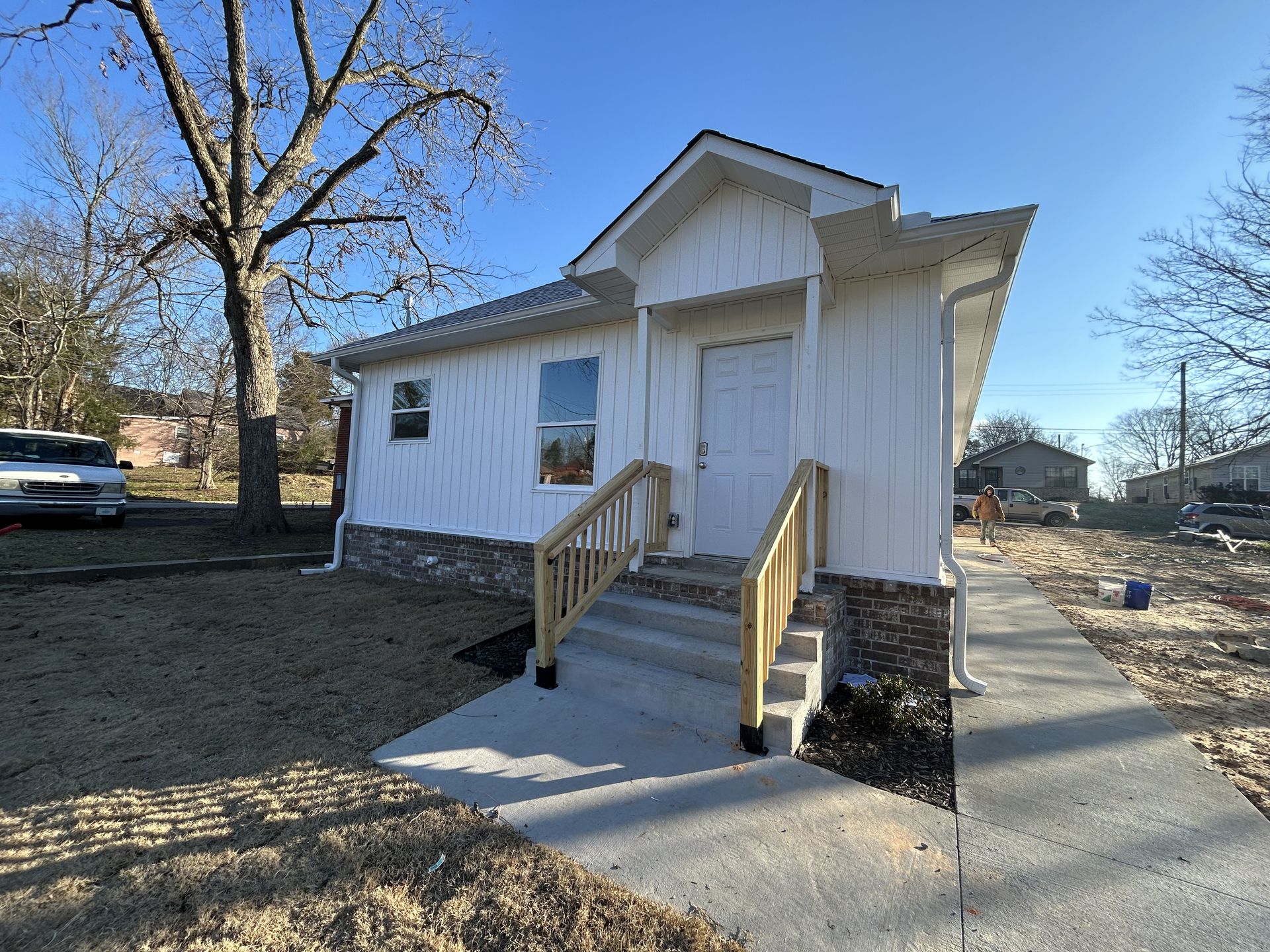 A small white house with wooden stairs leading up to it.