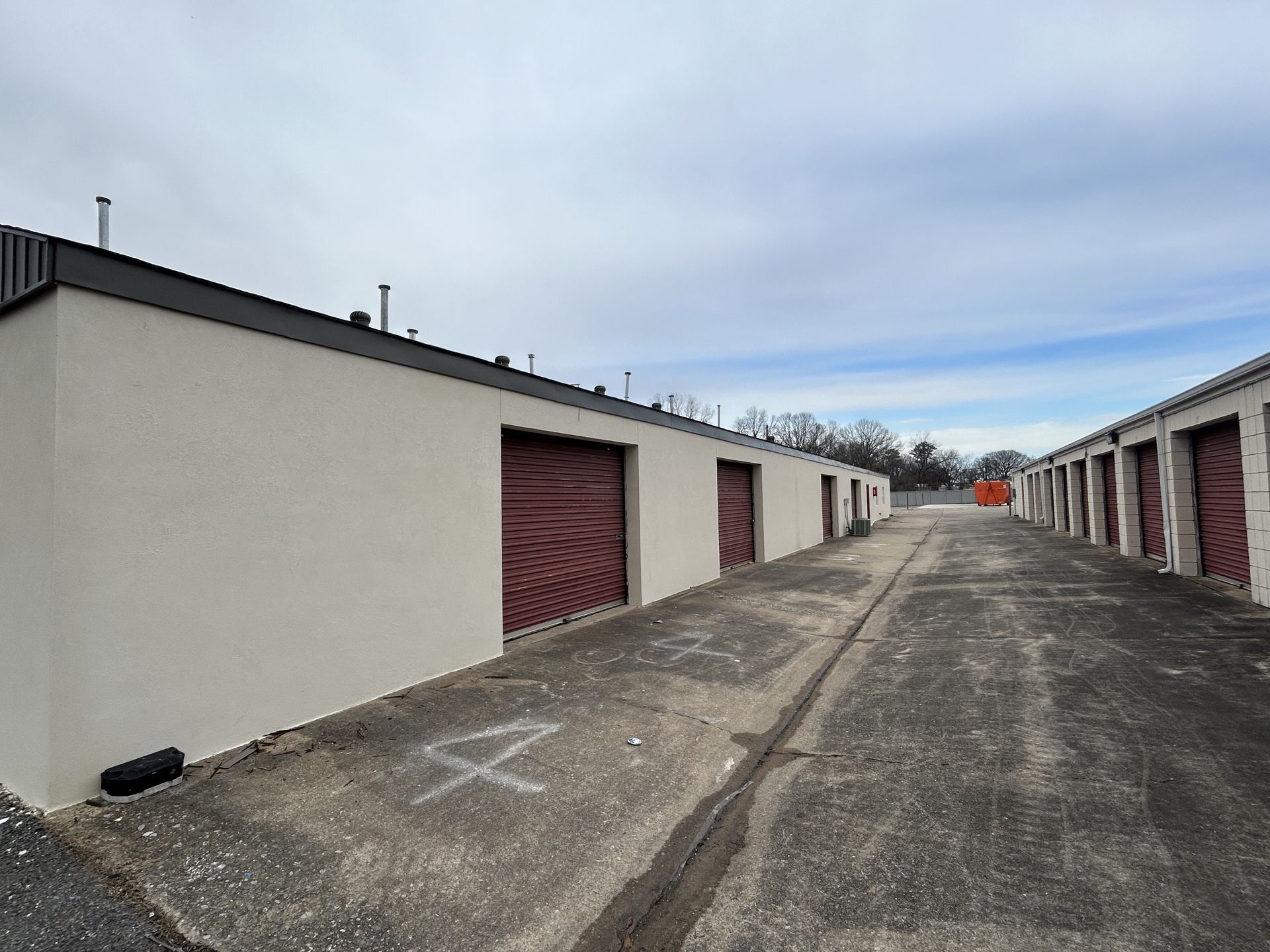 A row of storage units with a tire on the side of the road