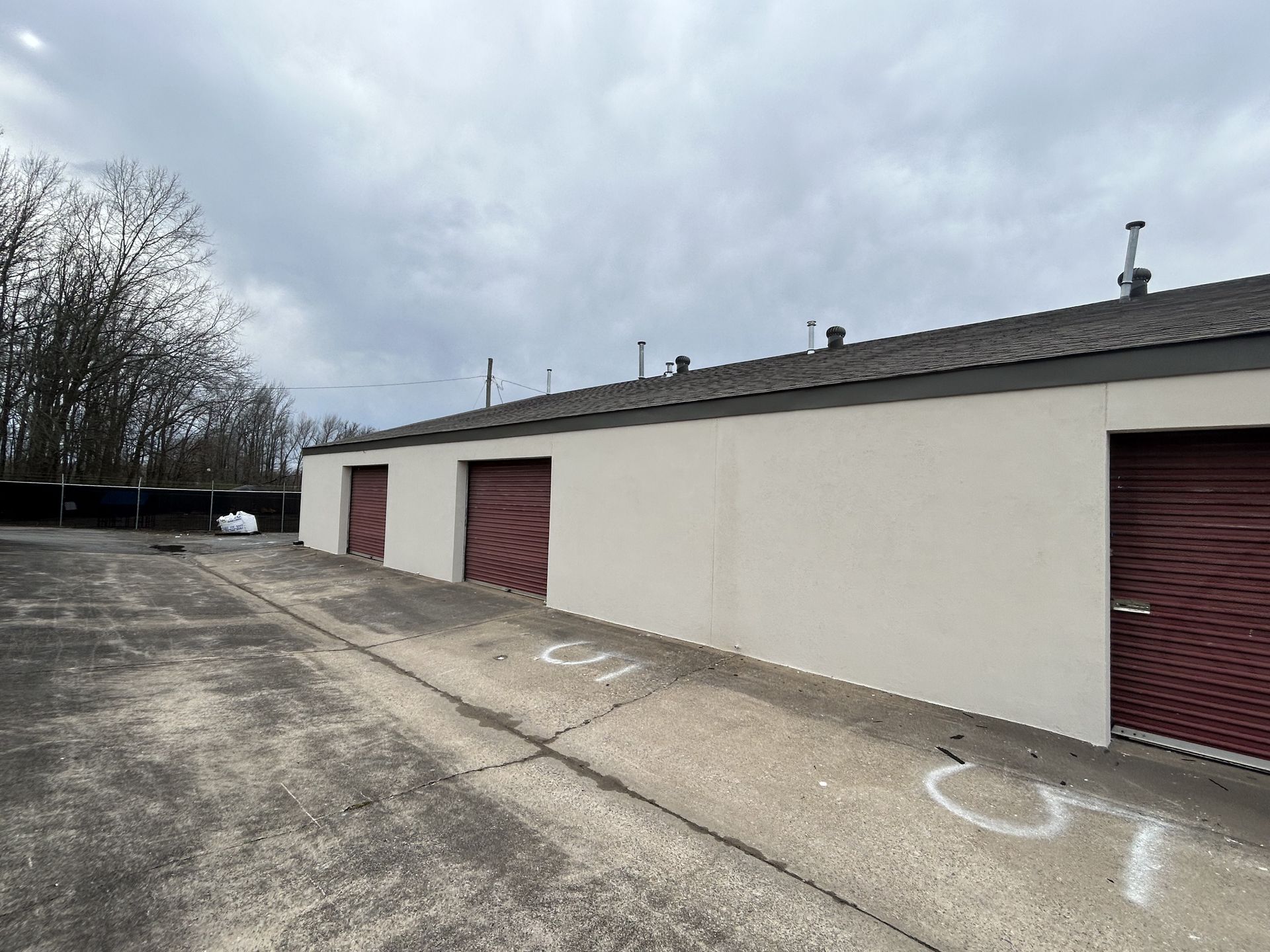 A row of storage units with red doors on a cloudy day.