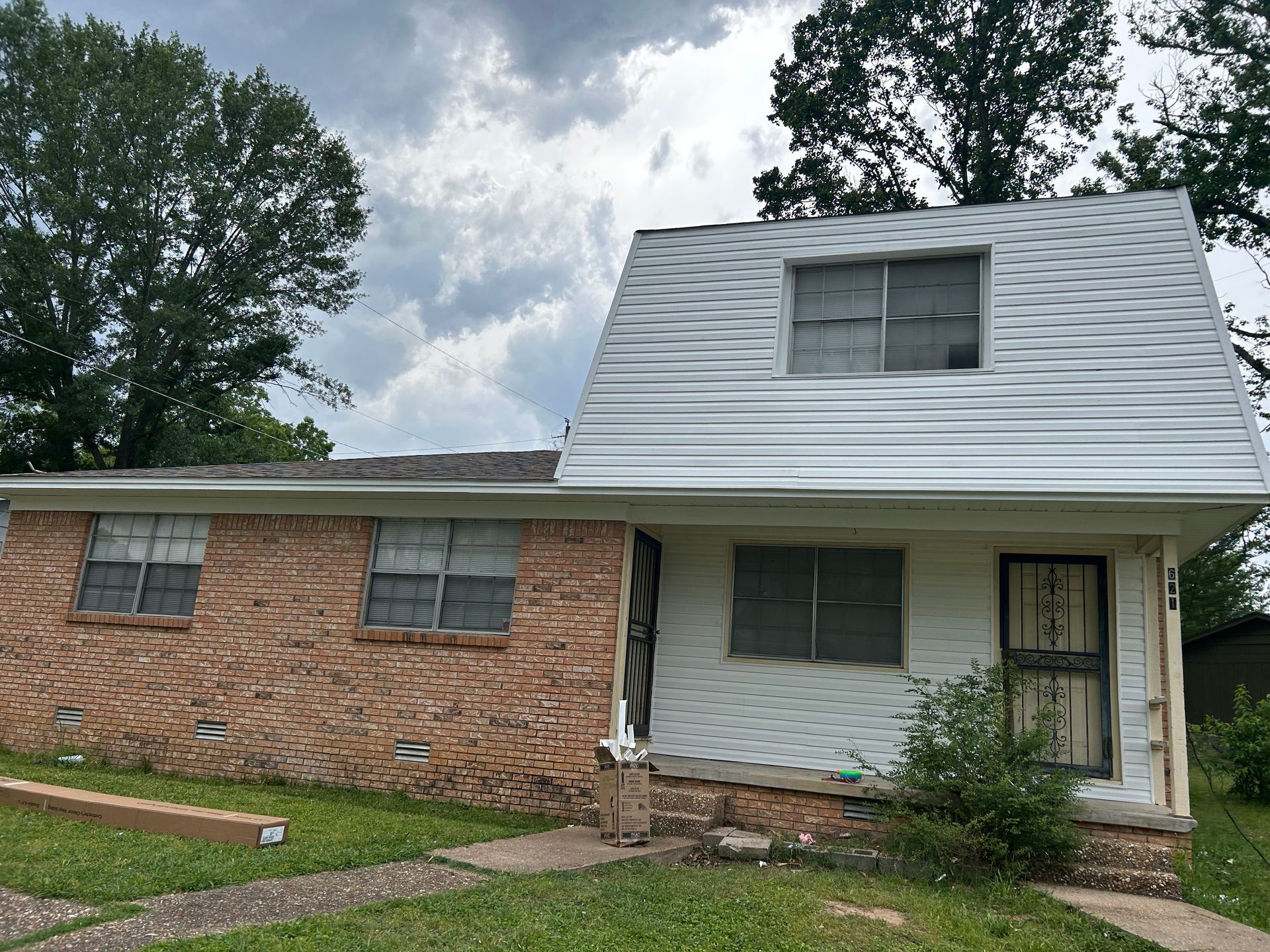 A brick house with a white roof is for sale.