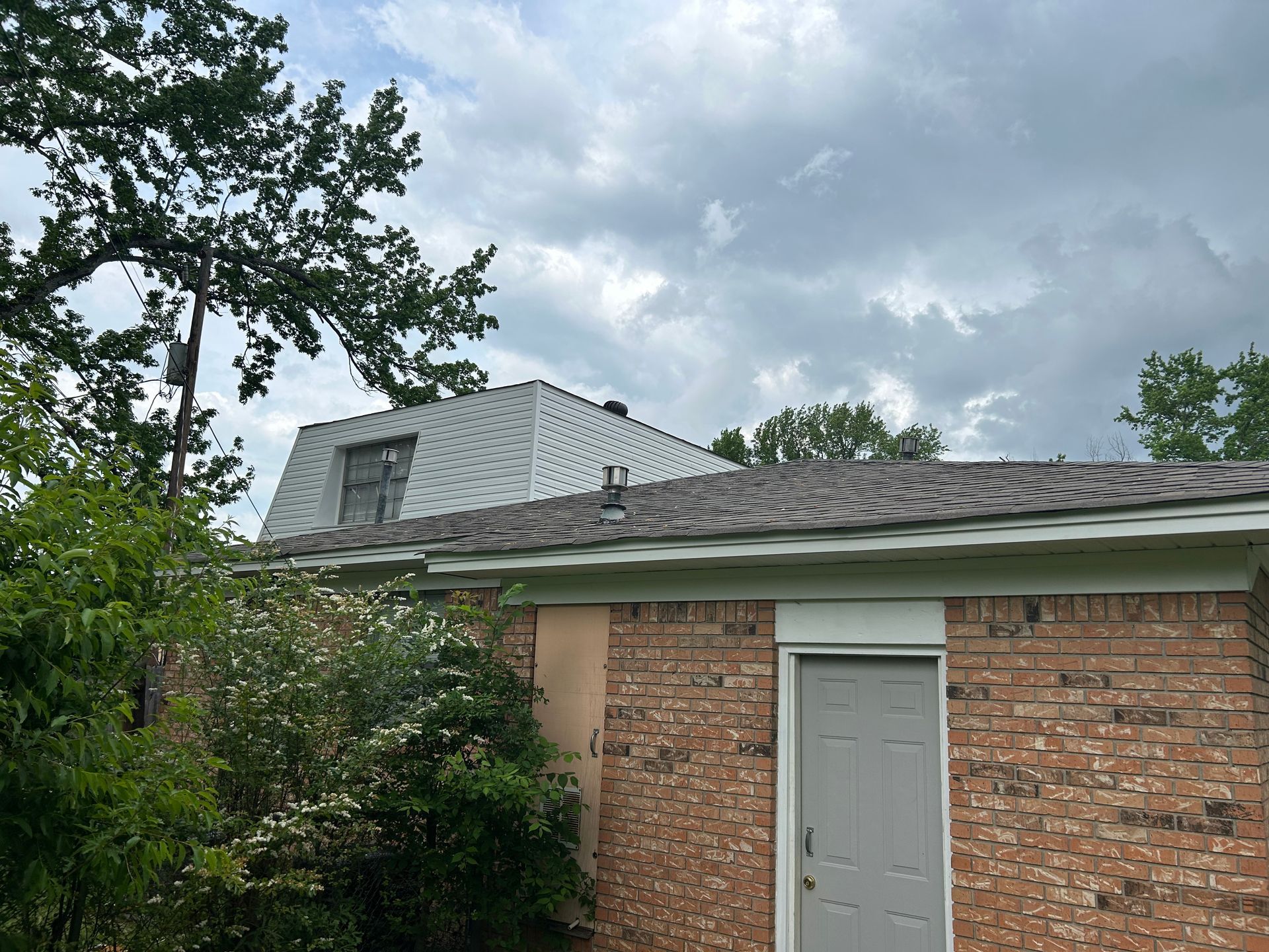 A brick house with a white roof and a white door