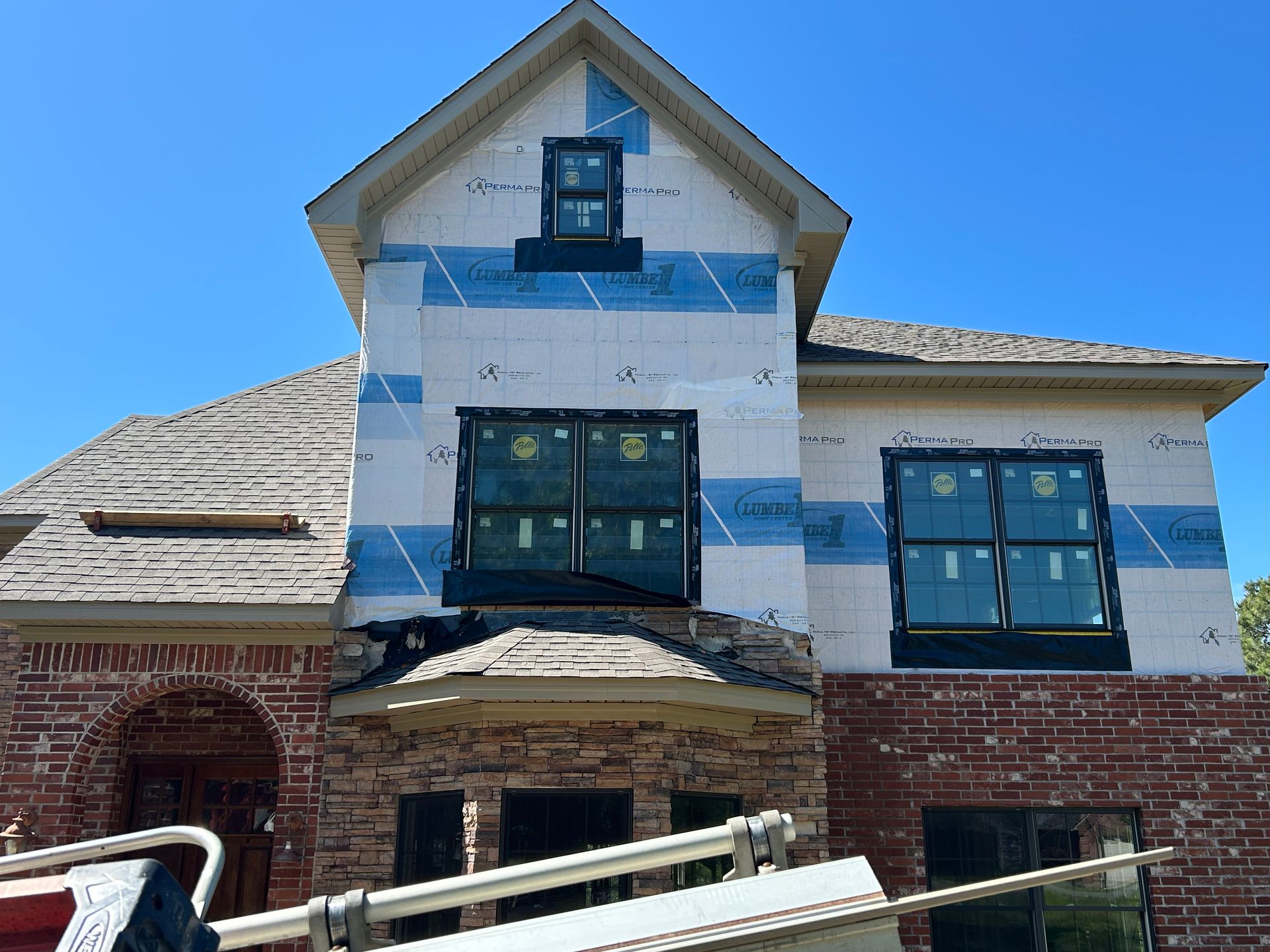 A brick house is being built with a lot of windows.