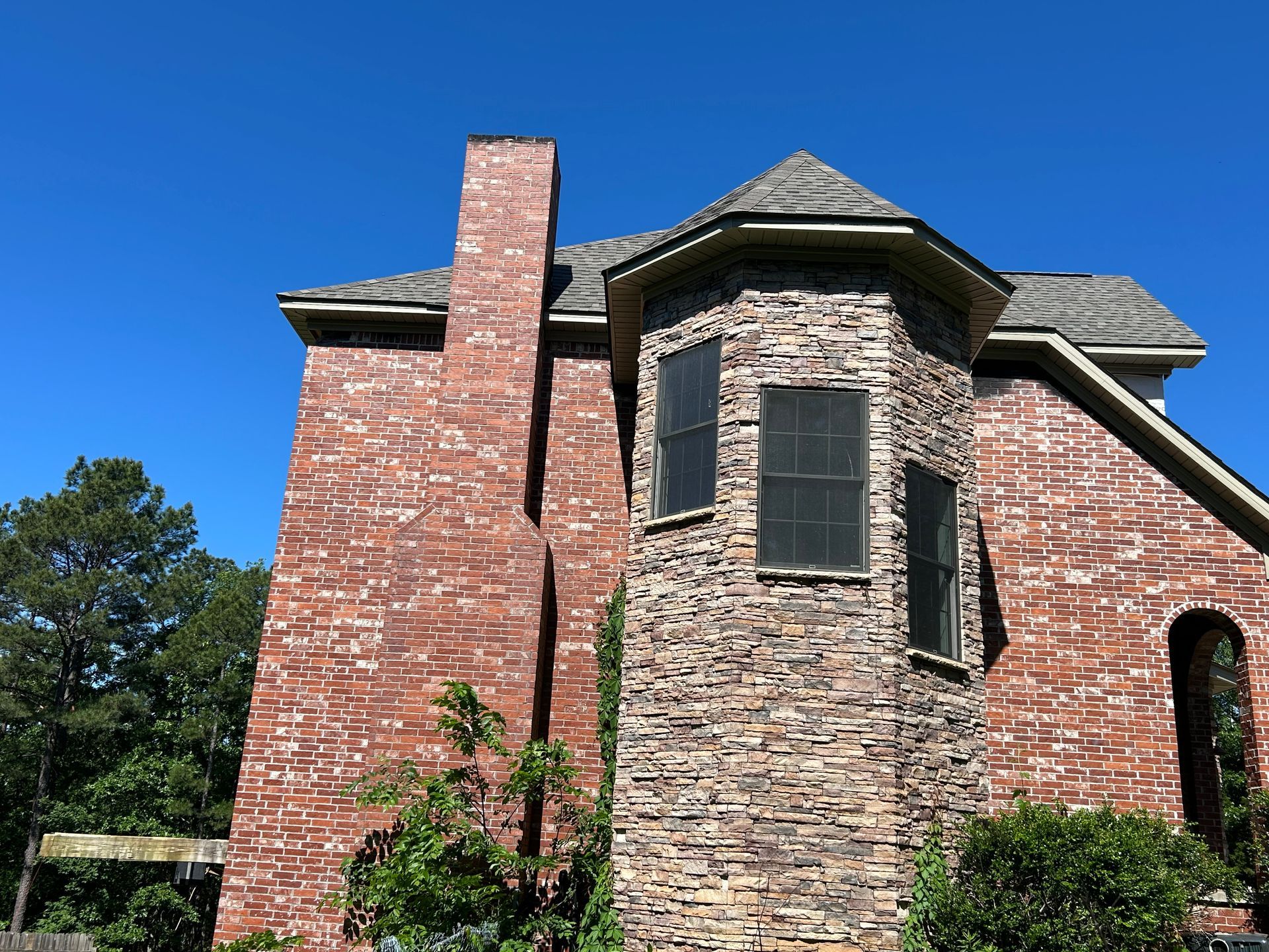 A large red brick house with a stone chimney