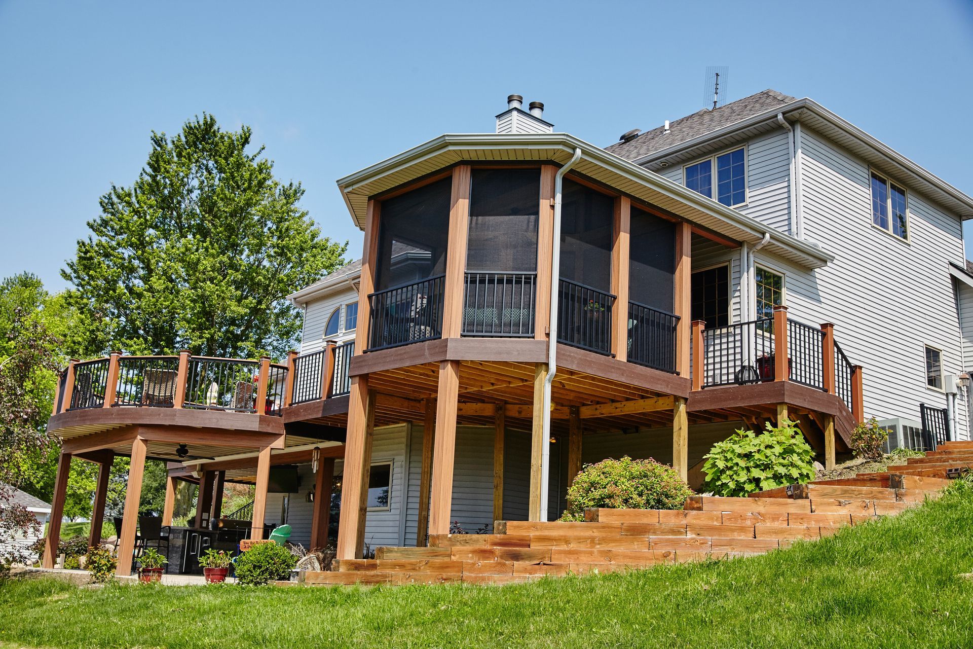 A large house with a large deck and screened in porch.