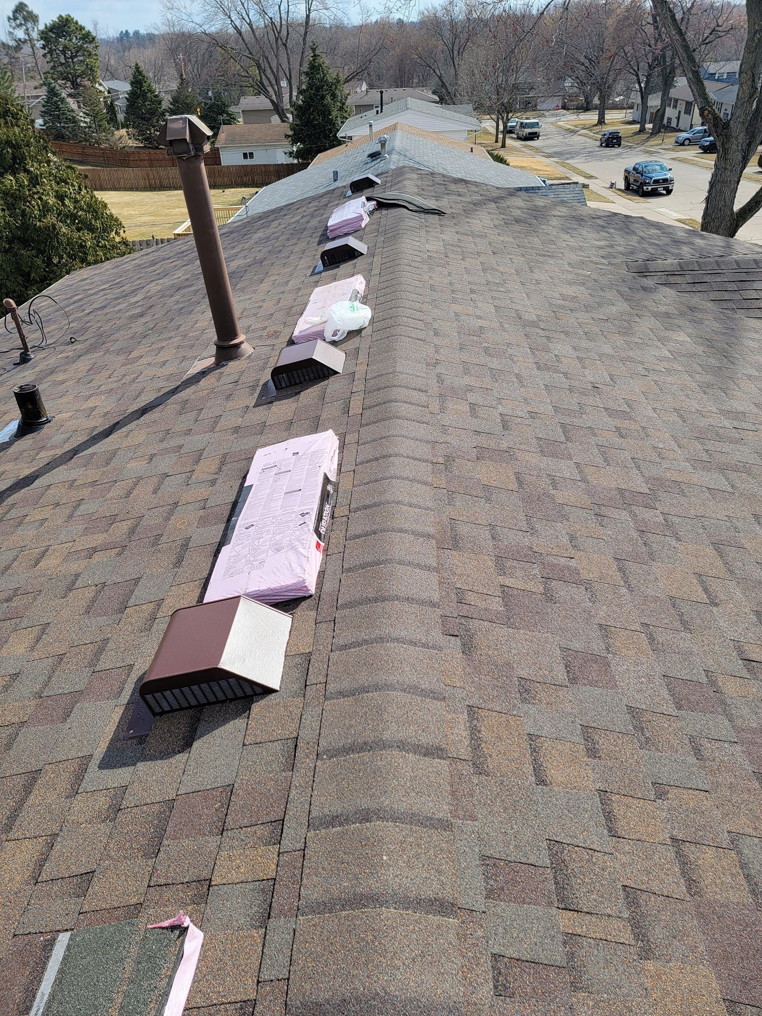 A roof with a lot of shingles and a chimney on it.