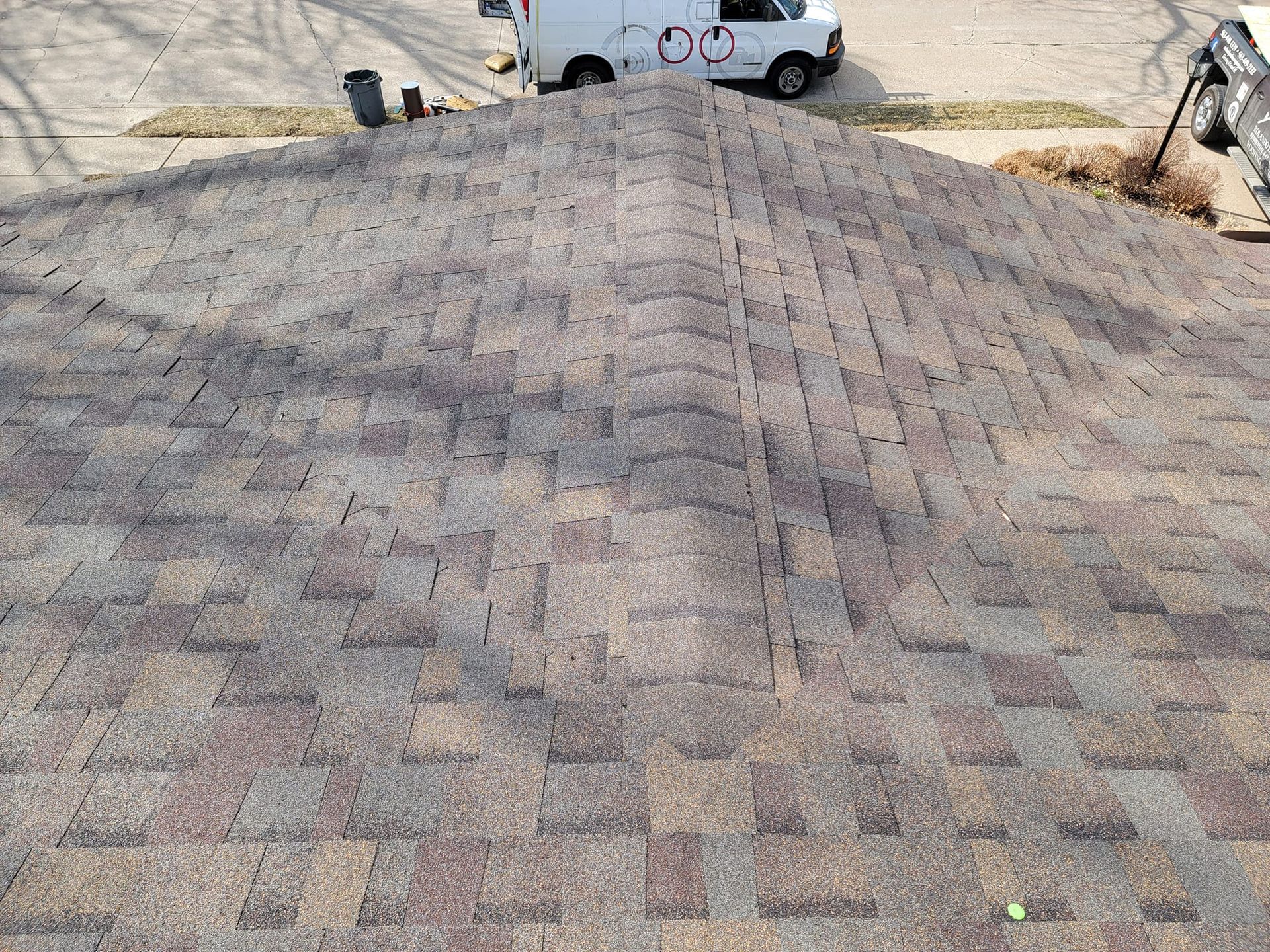 A white van is parked on the roof of a house.