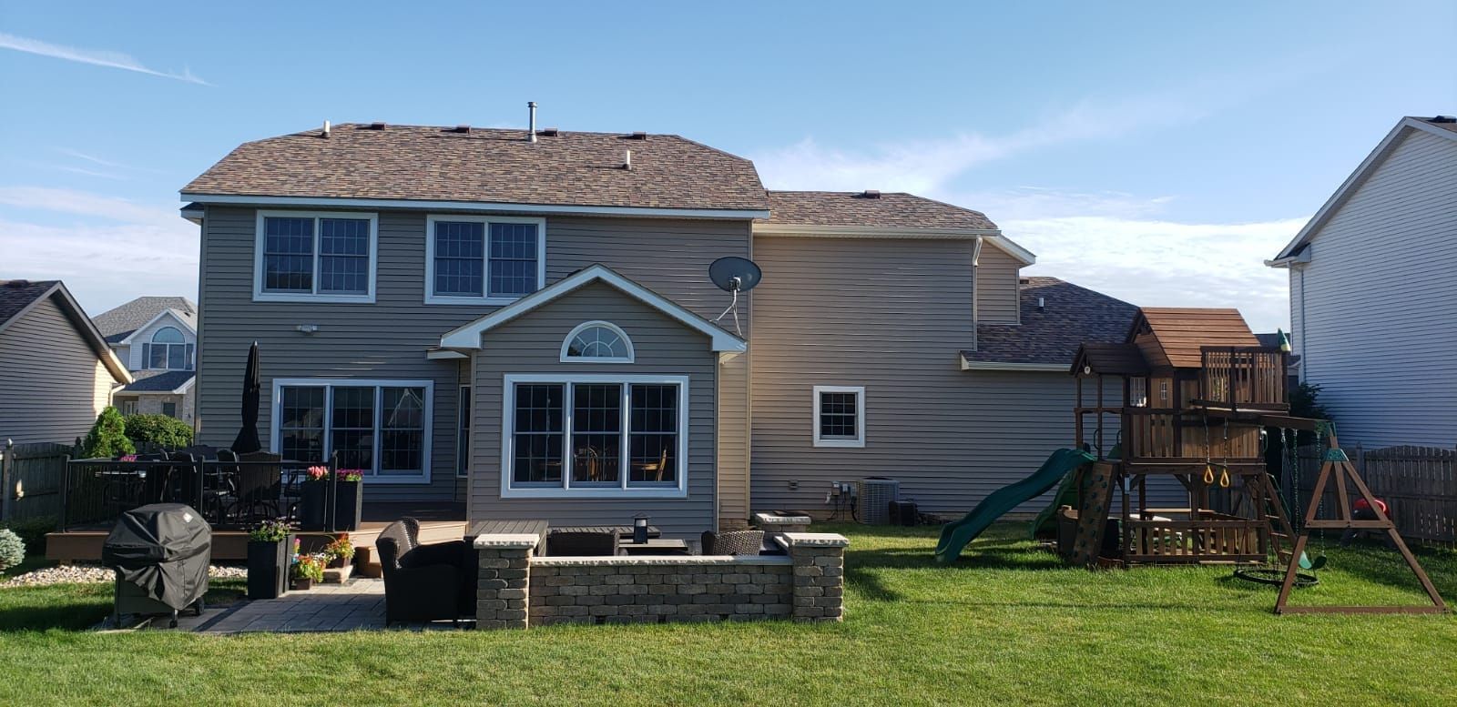 A large house with a playground in the backyard.