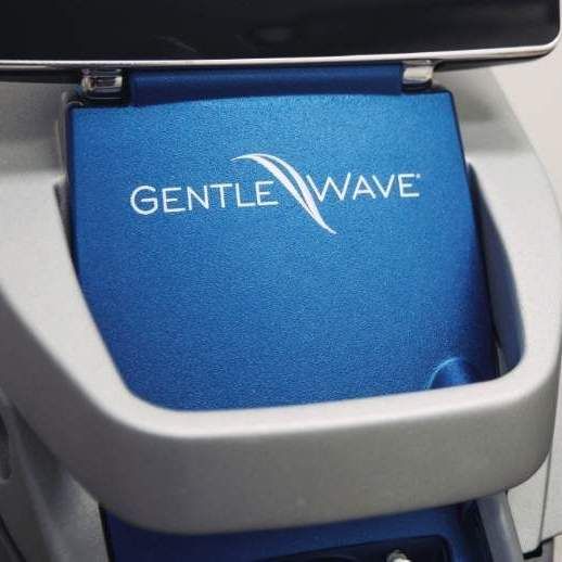 Close-up of a blue GentleWave dental device, with silver casing.