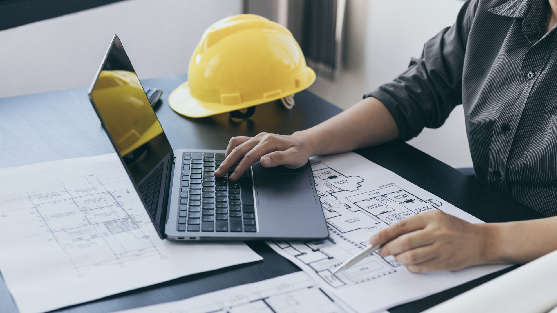 A person is sitting at a desk using a laptop computer.