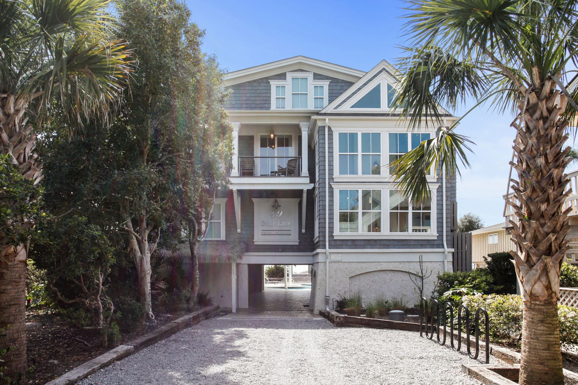 A large house with a driveway and palm trees in front of it