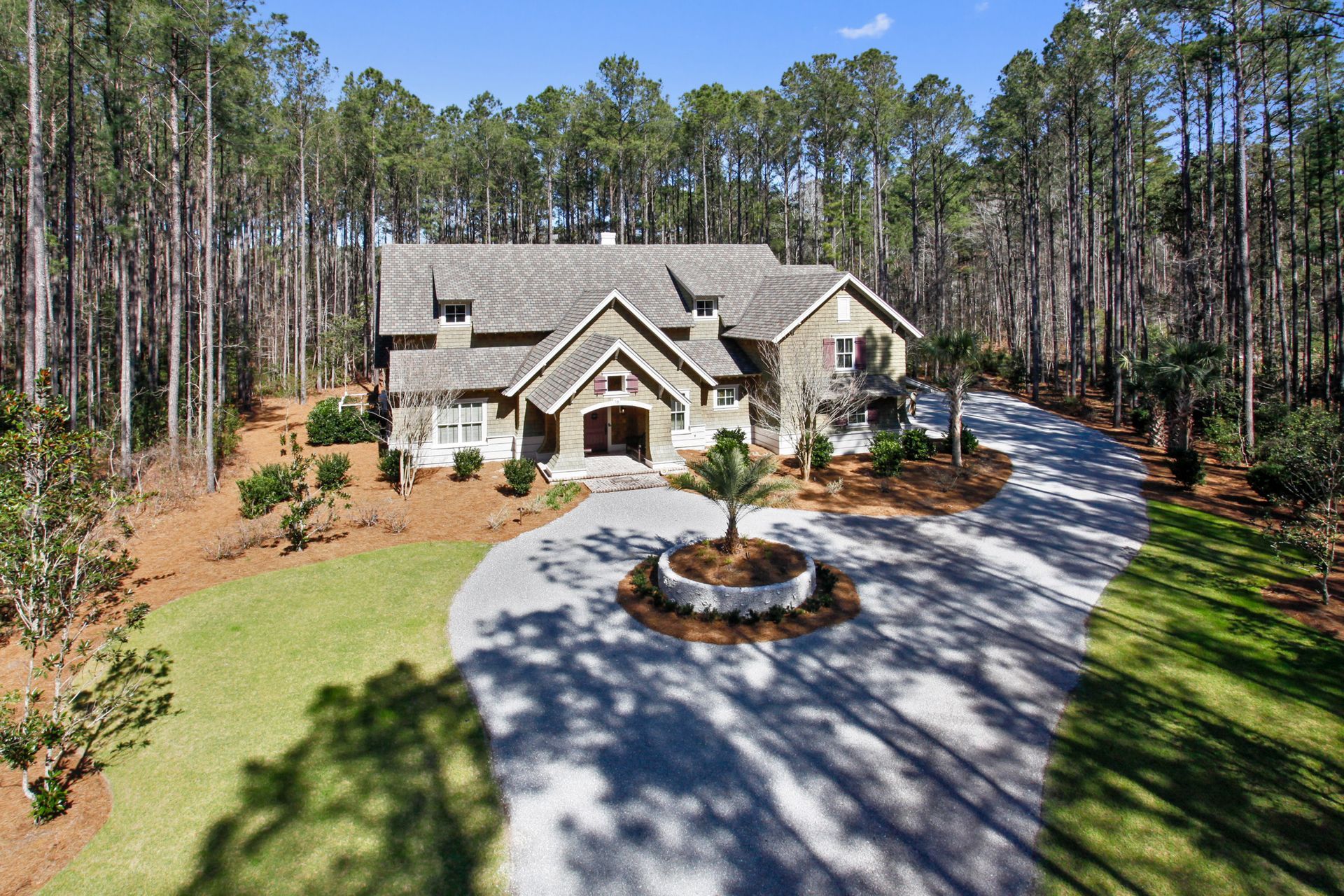 An aerial view of a house in the middle of a forest