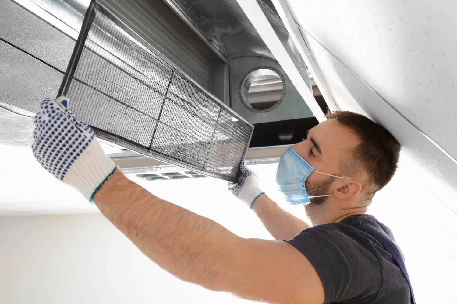 Man Cleaning Air Duct Filter