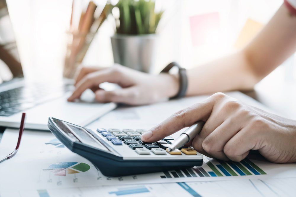 A Person Is Using a Calculator at A Desk — Cape York Accounting Smithfield in Smithfield, QLD