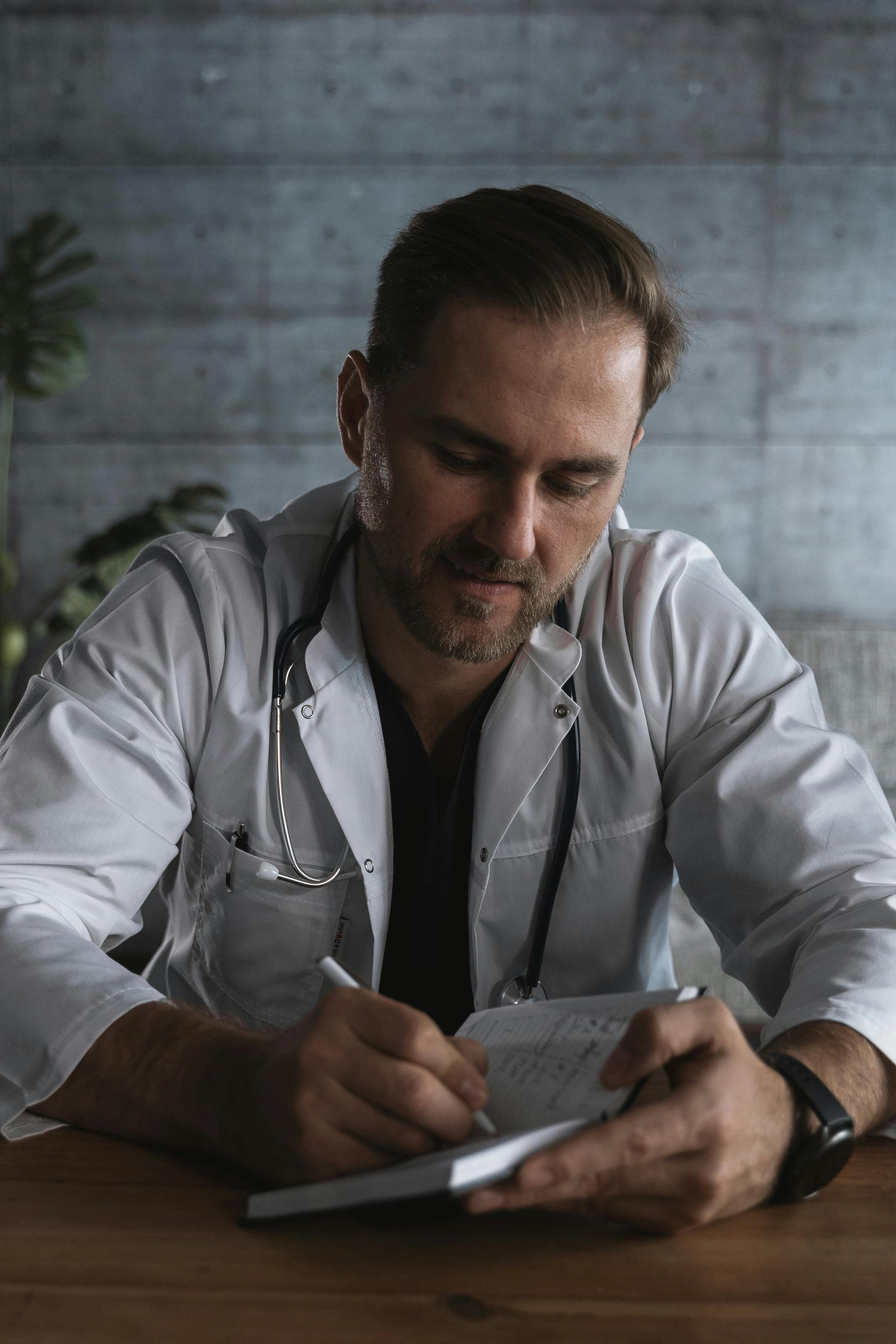 Doctor in a light shirt writing in a notebook, planning  marketing strategy