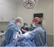 A group of surgeons are operating on a patient in an operating room.