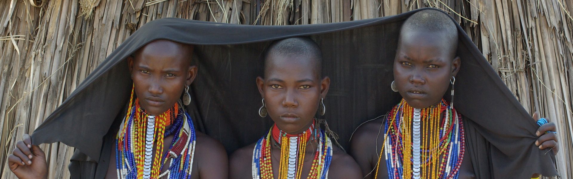 Admire the striking presence of three Erbore women in Ethiopia, looking confidently into the camera and adorned in vibrant, traditional beaded jewelry. Their colorful adornments and poised expressions celebrate the rich cultural heritage and artistic craftsmanship of the Omo Valley. This powerful portrait offers a rare and intimate glimpse into one of Africa’s most fascinating communities. Let Inspiration Africa craft your bespoke, tailor-made journey to explore Ethiopia’s extraordinary cultures and landscapes. Start planning your unforgettable adventure with us today!
