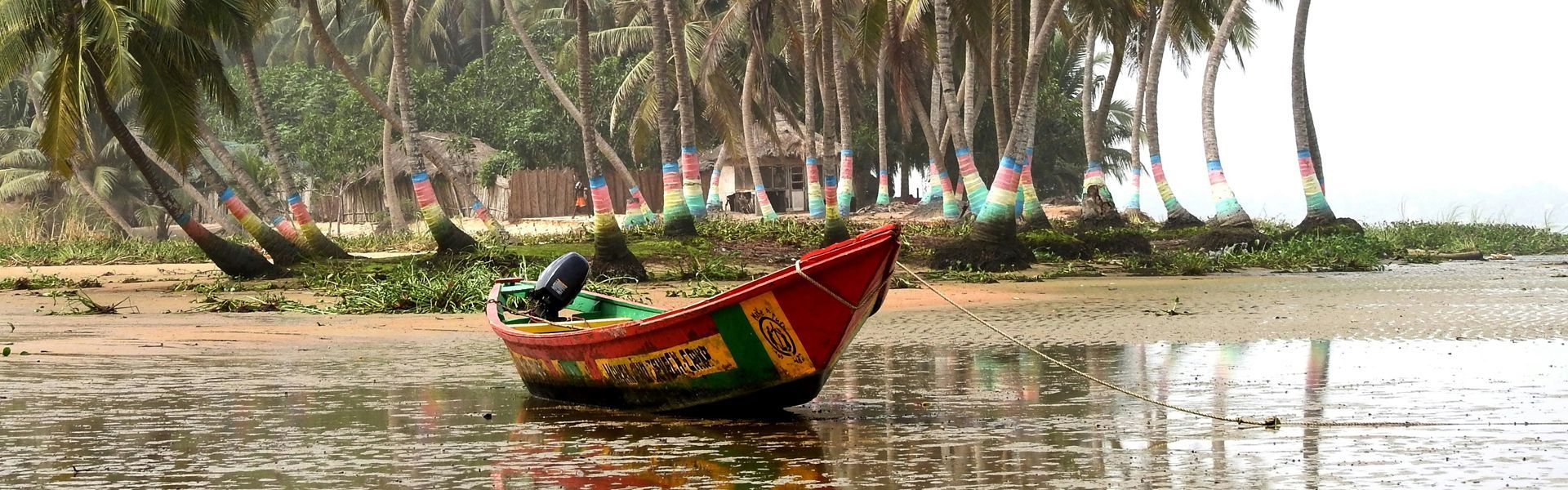 A vividly painted fishing boat rests on the sand at low tide, backed by palm trees and beach huts—each touched with color that captures the spirit of Ghana’s coast. This vibrant scene reflects everyday life along the shoreline, where tradition and creativity meet. Inspiration Africa organizes tailor-made travel to Ghana, offering immersive experiences that connect you with the country’s rich coastal culture. From colorful fishing villages to scenic beaches and local encounters, we help you explore Ghana beyond the guidebooks. Let us take you there—where every tide reveals more than just the sea.