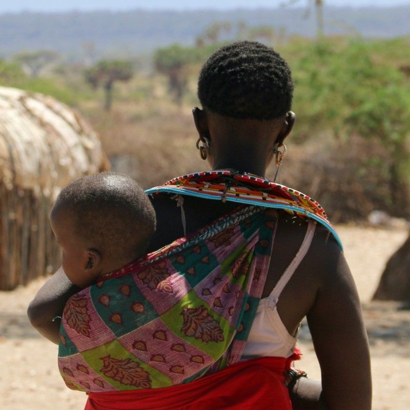 Capture a moment of daily life with this authentic photo of a Samburu woman in Kenya. She carries her baby securely on her back using a patterned cloth, showcasing a common and heartfelt tradition of the Samburu people. This image represents the enduring strength of Kenyan nomadic culture. Inspiration Africa specializes in designing your unique, tailor-made trip to Kenya for profound cultural encounters and exploring other spectacular destinations across Africa. Discover authentic Kenya with us!