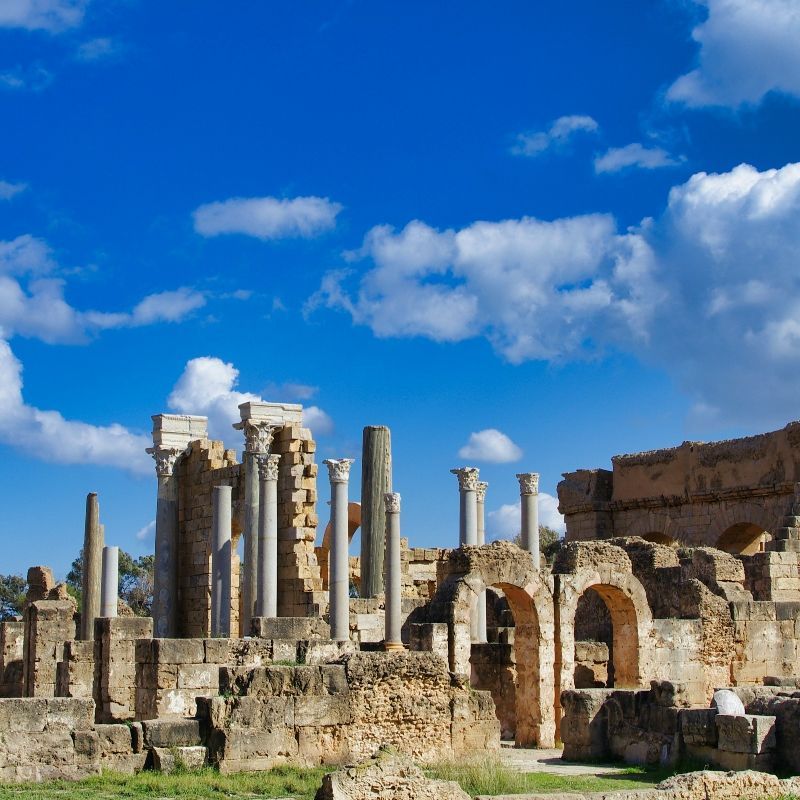 This image showcases the grandeur of Roman ruins in Libya, where ancient cities rise from the Mediterranean coast and desert sands. Among the most impressive sites are Leptis Magna and Sabratha, known for their theaters, temples, and monumental arches. These UNESCO-listed cities reveal the scale and sophistication of Roman Africa. 
