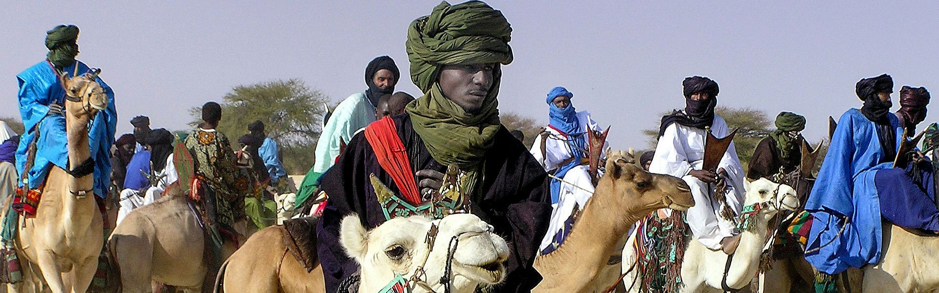 Meet Mali through a **Touareg man in traditional indigo wear**—veil, turban, and layered robes set against Saharan dunes and desert light. This image reflects living traditions of caravan routes, music, and artisan silverwork from Timbuktu to the Adrar des Ifoghas. **Inspiration Africa** organizes tailor-made travel to Mali: expert guides, cultural encounters with local consent, festival timing, and safe logistics from Bamako to the north. Discover markets, desert camps, and crafts while we handle routes, permits, and meaningful community-led experiences.
