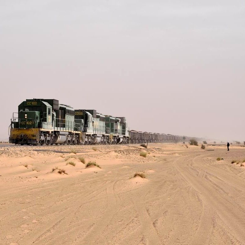 Experience the stark beauty of the Sahara with this powerful photo of Mauritania’s legendary iron ore train. Stretching across the desert like an endless steel serpent, the train carves its way through vast expanses of golden sand under a brilliant, cloudless sky. The rugged carriages and dramatic landscape capture the raw isolation and adventure of one of the world’s longest and heaviest trains. Inspiration Africa creates tailor-made journeys that immerse you in extraordinary cultural experiences and remote desert scenery. Let us design your personalized adventure to witness the iconic iron ore train and the striking beauty of Mauritania’s wilderness.