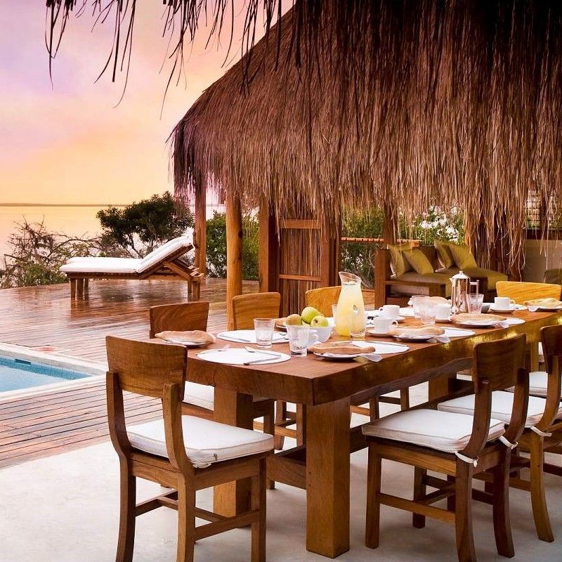 The outdoor dining area at Rio Azul Laisse in Mozambique is captured in this inviting travel photograph, showcasing a relaxed and scenic setting amid tropical greenery with views of the Indian Ocean. Tables are arranged to maximize the connection to the surrounding landscape, while natural wooden furnishings and thatched or shaded structures create a comfortable and welcoming atmosphere. Gentle sunlight filters through the trees, highlighting the vibrant colors and textures of the space. The scene conveys casual elegance, tranquility, and a deep sense of place, emphasizing Rio Azul Laisse as an ideal location to enjoy meals while immersed in Mozambique’s coastal beauty. Inspiration Africa specializes in bespoke, tailor-made journeys to Mozambique and across Africa, crafting unforgettable travel experiences in extraordinary destinations.
