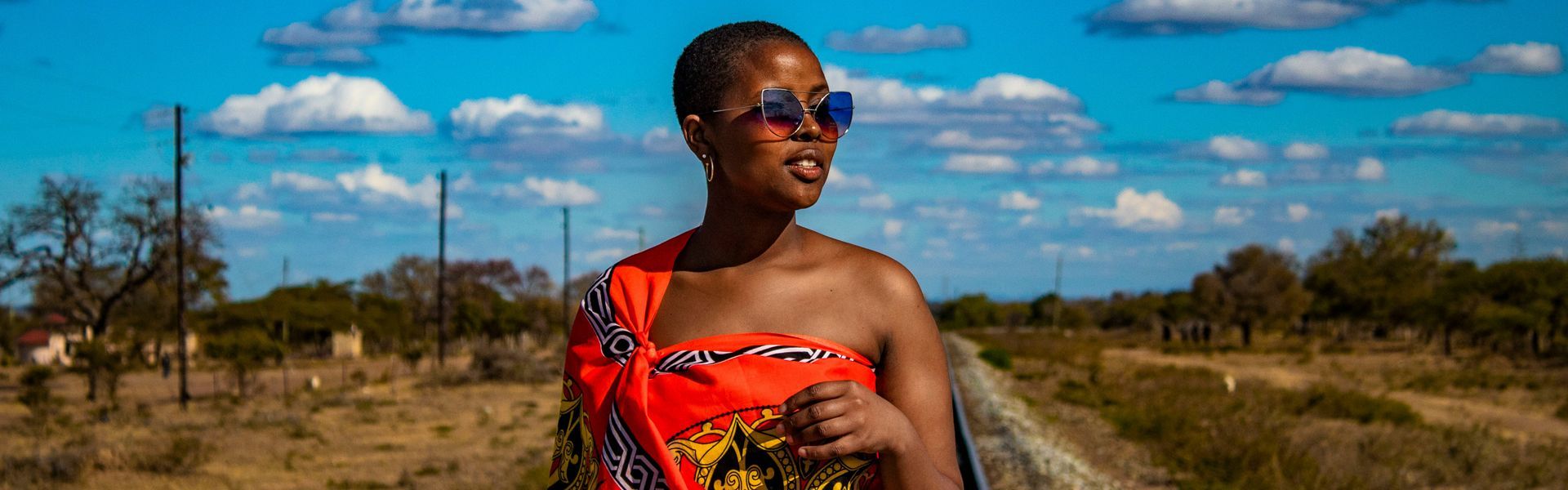 A striking Eswatini moment: a young woman in a one-shoulder red dress and sunglasses—poised between tradition and modern style. This image captures the kingdom’s effortless grace, from vibrant festivals to warm village welcomes. Inspiration Africa organizes tailor-made travel to Eswatini, combining cultural experiences with scenic walks, wildlife encounters, and characterful lodges. We plan seamless routes, trusted guides, and easy add-ons to neighboring destinations. Discover color, rhythm, and contemporary flair—your Eswatini journey starts here with Inspiration Africa.