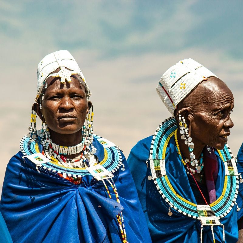 This compelling image celebrates the wisdom of the Maasai with a photo of two elderly women from the Ngorongoro region. They are beautifully dressed in traditional, striking blue Maasai clothing, representing their rich cultural legacy in Tanzania. Inspiration Africa specializes in designing your unique, tailor-made trip to Ngorongoro for authentic cultural immersion and unforgettable safari experiences across Africa. Experience the heart of the Maasai lands with us!