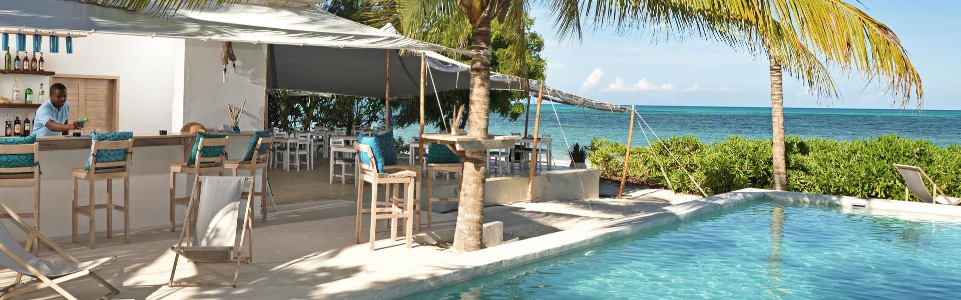 A serene moment at Sharazad Boutique Hotel in Zanzibar, Tanzania, is captured in this elegant travel photograph, showing a woman sunbathing in the hotel’s inviting swimming pool. Surrounded by palm trees, whitewashed architecture, and soft coastal tones, the pool reflects the relaxed, bohemian charm the hotel is known for. Gentle sunlight glimmers on the water’s surface, enhancing the sense of calm and effortless luxury, while the intimate setting creates a feeling of privacy and escape. The scene conveys tranquility, warmth, and barefoot indulgence, highlighting Sharazad Boutique Hotel as a stylish seaside retreat where relaxed elegance meets the timeless beauty of Zanzibar’s coastline. Inspiration Africa specializes in bespoke, tailor-made journeys to Tanzania and across Africa, crafting unforgettable travel experiences in extraordinary destinations.
