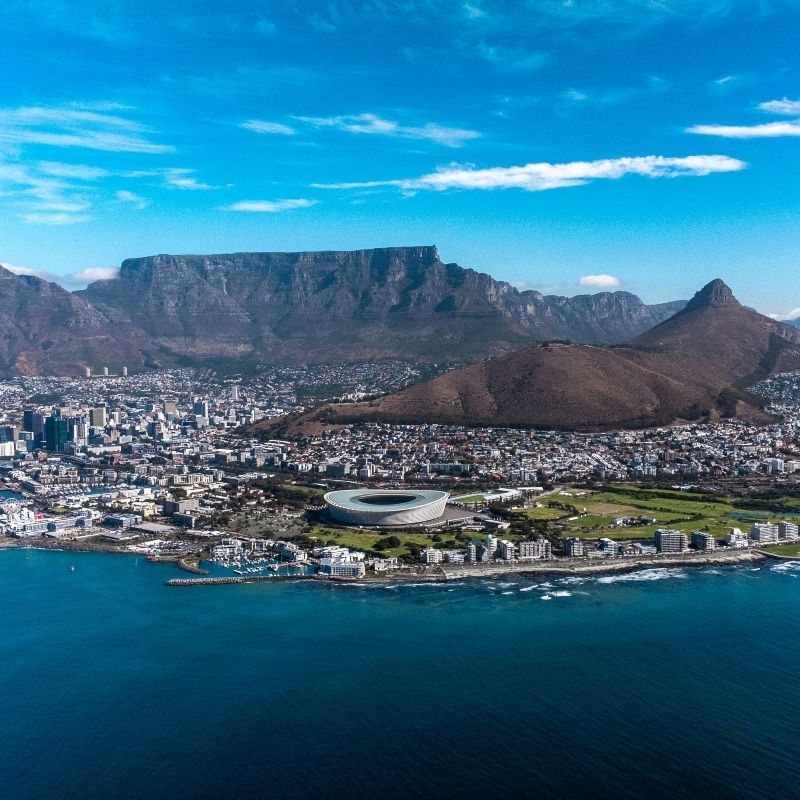 Gaze upon a breathtaking aerial view of Cape Town, South Africa, where the vibrant city meets the Atlantic Ocean, with Table Mountain rising majestically in the background and the iconic stadium visible below. This striking photograph captures the unique blend of natural beauty and urban energy that defines Cape Town, highlighting its dramatic coastline, bustling neighborhoods, and iconic landmarks. Experiencing the city from above offers a spectacular perspective of one of Africa’s most scenic and dynamic destinations. Inspiration Africa specializes in designing bespoke, tailor-made journeys that combine urban exploration with extraordinary natural landscapes across Africa’s most remarkable destinations.
