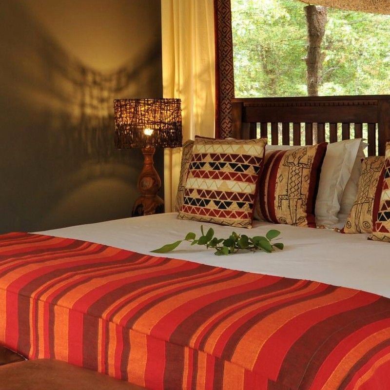 The interior of one of the tents at Changa Safari Camp in Zimbabwe is captured in this inviting travel photograph, showcasing a comfortable and thoughtfully designed space set within the heart of Hwange National Park. A well-appointed bed, natural wooden furnishings, and soft neutral tones create a warm and relaxing atmosphere that reflects the textures and colors of the surrounding bush. Large openings and canvas walls allow natural light and fresh air to fill the space, while offering unobstructed views of the wilderness and nearby wildlife. The interior balances authentic safari-style living with understated comfort, providing guests with a serene retreat immersed in one of Zimbabwe’s most wildlife-rich environments. Inspiration Africa specializes in bespoke, tailor-made journeys to Zimbabwe and across Africa, crafting unforgettable safari experiences in extraordinary wilderness destinations.
