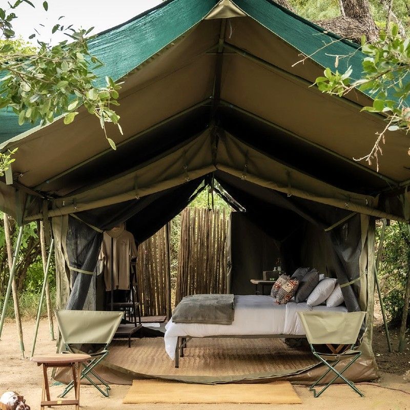 The exterior of one of the tents at Chilo Gorge Tented Camp in Zimbabwe is captured in this atmospheric travel photograph, set within the dramatic landscapes of the Chilojo Cliffs and surrounding wilderness. Canvas walls and natural wooden structures blend seamlessly with the rugged terrain, indigenous vegetation, and distant hills, creating a sense of harmony with the environment. Elevated decks and open pathways invite guests to step outside and enjoy panoramic views of the gorge and valley below, where wildlife may be spotted moving through the bush. The setting balances authentic safari-style living with understated comfort, offering an immersive and memorable experience in one of Zimbabwe’s most remote and striking natural regions. Inspiration Africa specializes in bespoke, tailor-made journeys to Zimbabwe and across Africa, crafting unforgettable safari experiences in extraordinary wilderness destinations.
